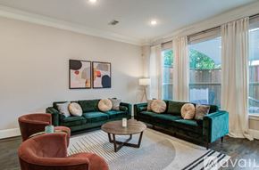 Houston house for rent - A kitchen with white cabinets and a center island with bar stools.