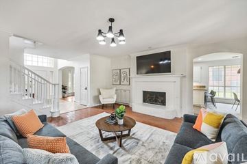 Plano house for rent - A living room with a grey couch and a white fireplace.