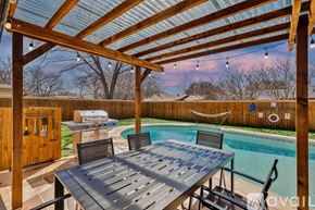 Fort Worth house for rent - A wooden pergola over a table with a pool in the background.