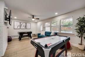 Plano house for rent - A pool table is in the middle of a room with a couch and a TV.