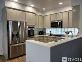 Huntington Beach house for rent - A modern kitchen with a stainless steel refrigerator and a white island.