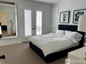 Huntington Beach house for rent - A bedroom with a large bed and a mirror on the wall.