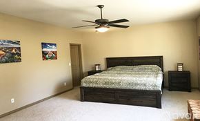 Prescott house for rent - A bedroom with a bed, a ceiling fan, and two pictures on the wall.