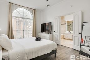 Rowlett house for rent - A bedroom with a large bed and a television in the corner.