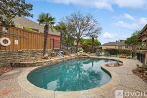 Rowlett house for rent - A small kidney-shaped pool with a stone border.