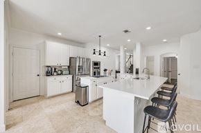 Rowlett house for rent - A modern kitchen with white cabinets and a large island.