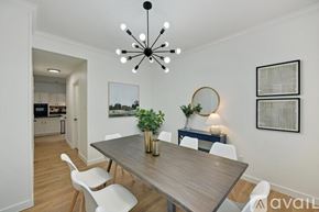 Plano house for rent - A modern dining room with a wooden table and white chairs.