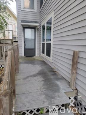 Aransas Pass apartment for rent - A grey house with a wooden deck and a glass door.