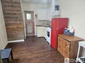 Aransas Pass apartment for rent - A kitchen with a red fridge and wooden floors.
