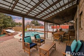 Rowlett house for rent - A patio with a table and chairs overlooking a pool.