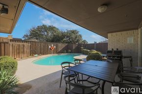 Plano house for rent - A pool area with a table and chairs under a roof.