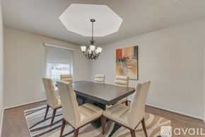 Plano house for rent - A dining room with a table and chairs and a chandelier.