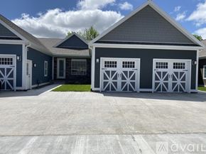 New Hartford townhouse for rent - A two-car garage with a blue house in the background.