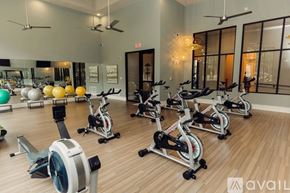 Mckinney apartment for rent - A gym with exercise equipment and mirrors on the wall.