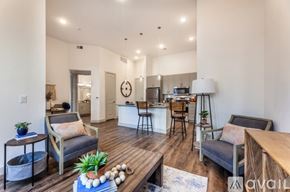 Mckinney apartment for rent - A living room with a grey couch, a wooden table, and a white lamp.
