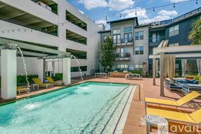 Dallas apartment for rent - A pool area with yellow sun loungers and a white building in the background.