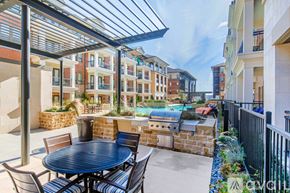 Fort Worth apartment for rent - A patio with a table and chairs is covered by a roof.