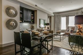 Fort Worth apartment for rent - A modern dining room with a dark wood floor and a glass table.