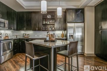 Fort Worth apartment for rent - A modern kitchen with dark wood cabinets and stainless steel appliances.