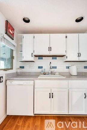 Weston apartment for rent - A kitchen with white cabinets and a wooden floor.
