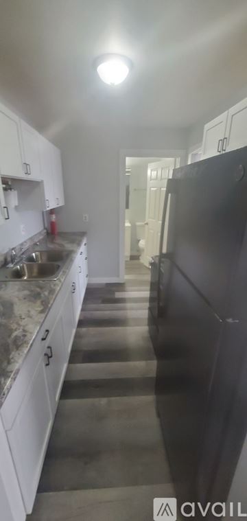 La Crosse apartment for rent - A kitchen with white appliances and brown cabinets.