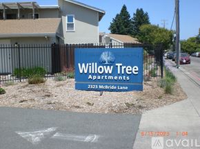 Santa Rosa apartment for rent - A blue sign for Willow Tree Apartments is in front of a house.