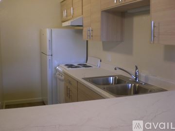 Santa Rosa apartment for rent - A kitchen with a white refrigerator and wooden cabinets.