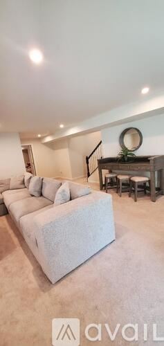 Stafford house for rent - A living room with a white couch and a mirror on the wall.