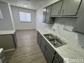 Fort Stockton apartment for rent - A kitchen with a marble countertop and wooden flooring.