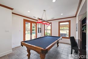 Mckinney house for rent - A pool table in a room with a light hanging from the ceiling.