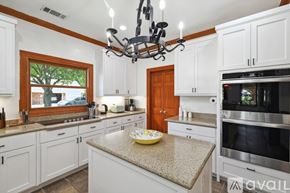 Mckinney house for rent - A kitchen with white cabinets and a granite countertop.
