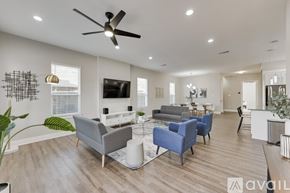 Dallas house for rent - A living room with a grey couch, blue armchair, and a television.