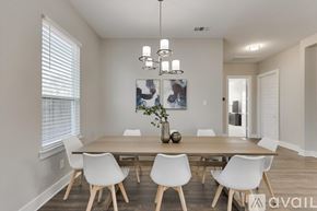 Dallas house for rent - A dining room with a wooden table and white chairs.