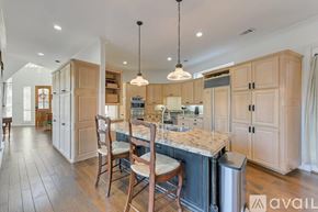Mesquite house for rent - A kitchen with wooden cabinets and a marble countertop.