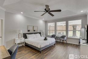 Grand Prairie house for rent - A bedroom with a large bed, a ceiling fan, and a television.