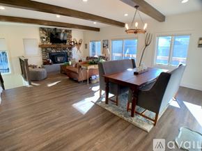 Ketchum house for rent - A large, well-lit living room with a wooden floor and a stone fireplace.