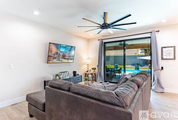 Lake Havasu City house for rent - A living room with a brown couch and a ceiling fan.