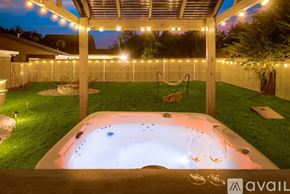 Arlington house for rent - A hot tub is surrounded by lights in a backyard.