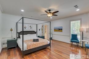 Richardson house for rent - A bedroom with a four poster bed and a ceiling fan.