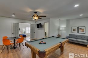 Richardson house for rent - A pool table is in the middle of a room with a couch, chairs, and a television.