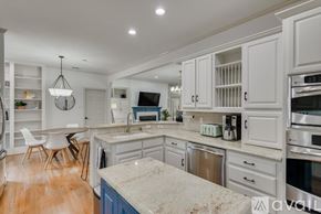 Richardson house for rent - A kitchen with white cabinets and a marble countertop.