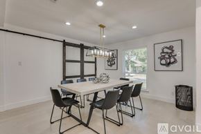 Dallas house for rent - A dining room with a white table and black chairs.
