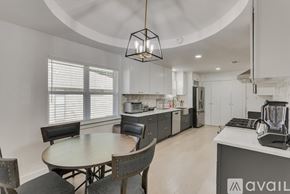 Dallas house for rent - A modern kitchen with a round table and chairs.
