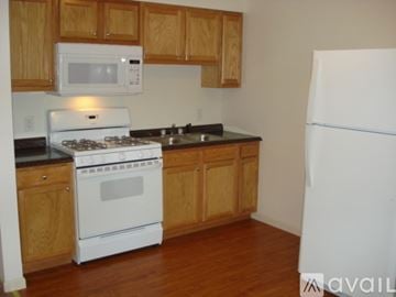 Toledo apartment for rent - A kitchen with a white fridge, white stove and white microwave.