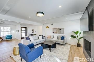 Dallas house for rent - A living room with a blue chair and a white couch.