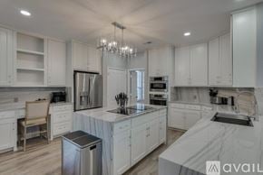 Rowlett house for rent - A modern kitchen with white cabinets and a marble countertop.