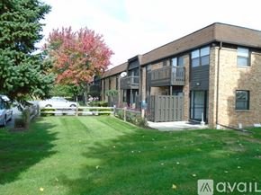 Maumee apartment for rent - A building with a green lawn in front of it.