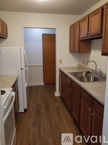 Maumee apartment for rent - A kitchen with wooden cabinets and a white fridge.