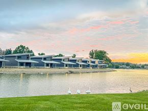 Columbiana house for rent - A serene lakeside scene with a modern building and a few birds.