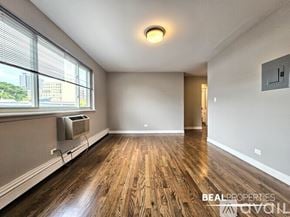 Chicago apartment for rent - A spacious room with wooden flooring and a window with blinds.